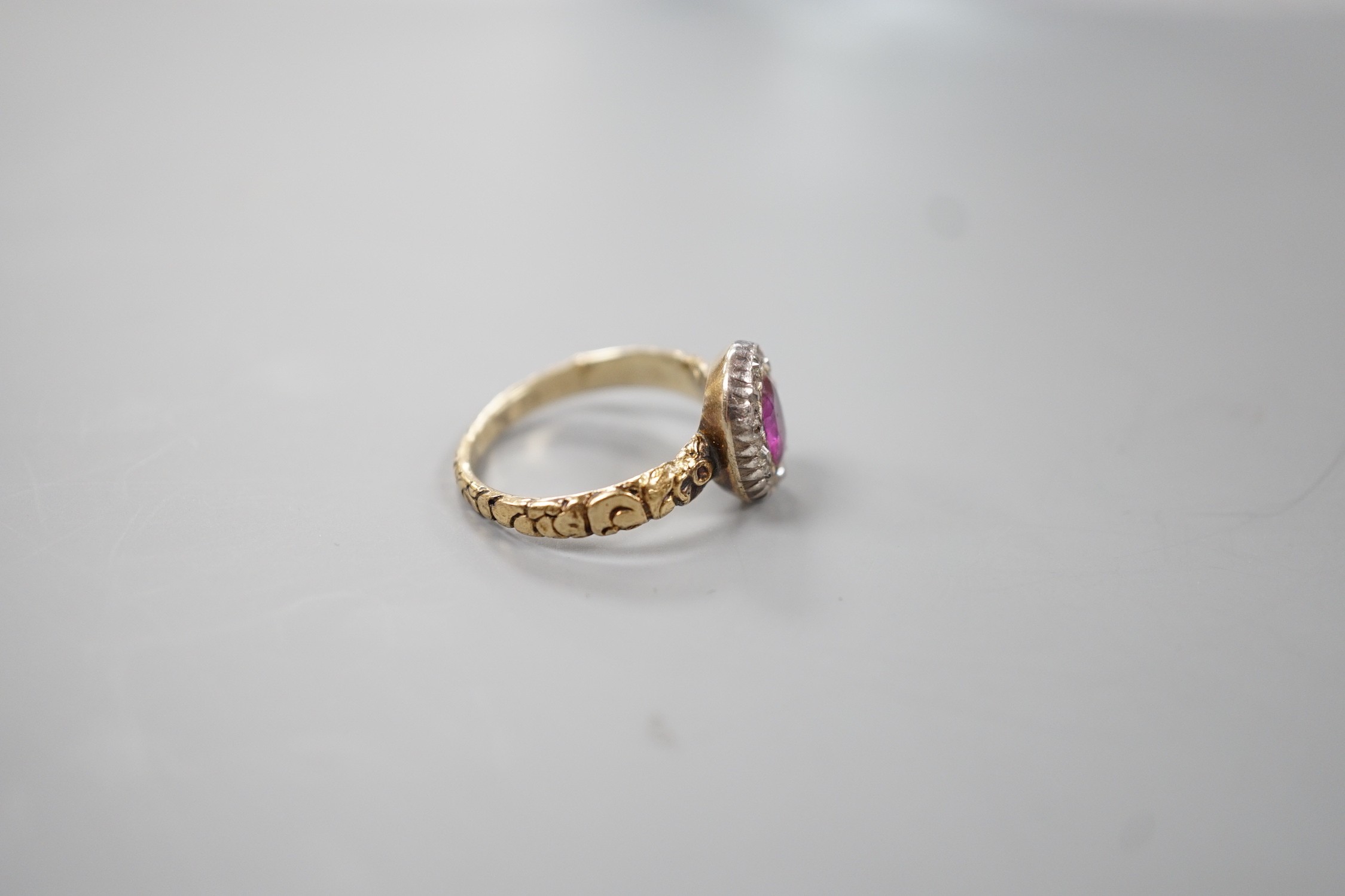 A 19th century yellow metal, garnet and diamond set oval cluster ring, size M, gross weight 2.2 grams.